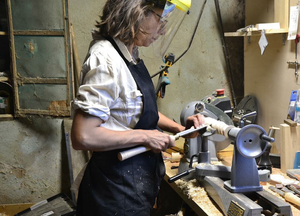 Femme - tourneur sur bois en train de tourner